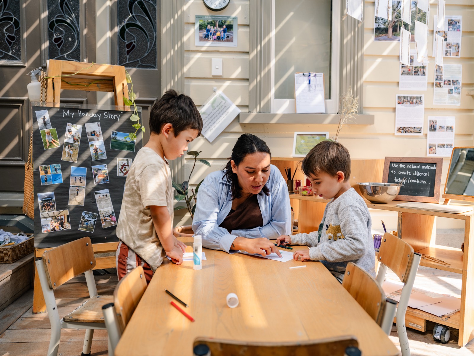 A teacher working alongside children at a table at a Bear Park centre