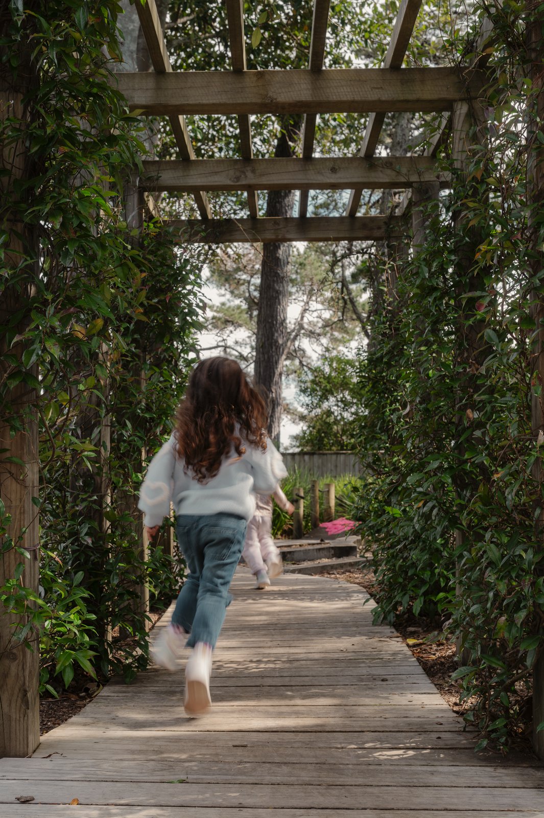 A child running along the pergola walk at Bear Park Hobsonville